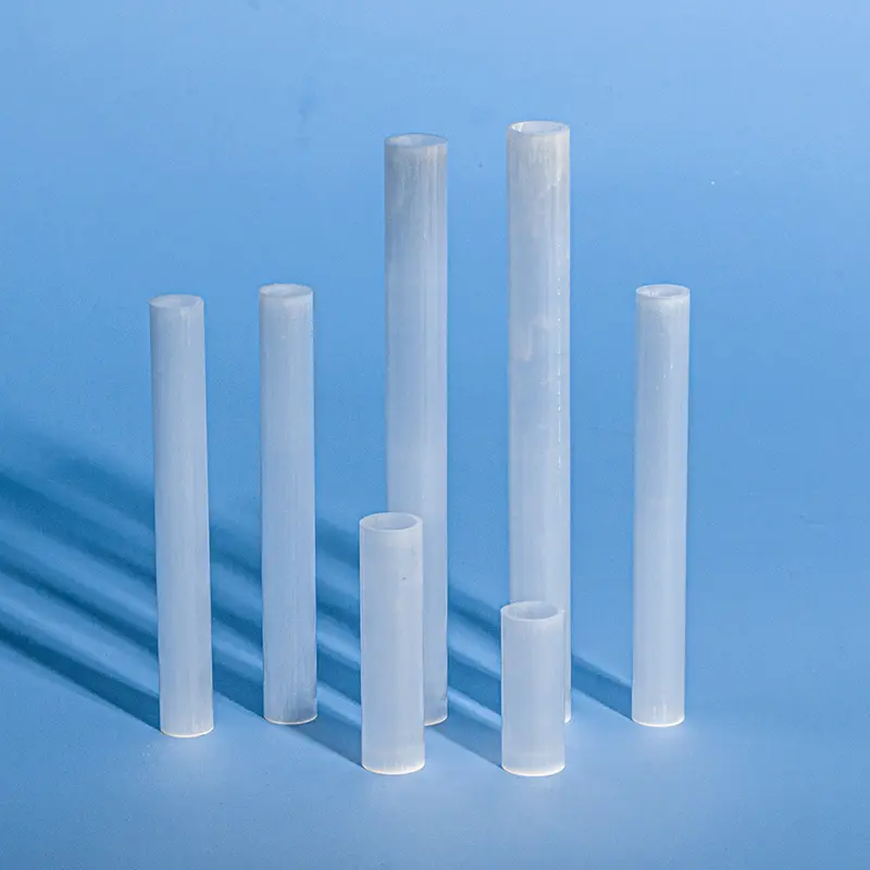 Assortment of opaque milky quartz tubes in various lengths and diameters, shown standing on a blue background