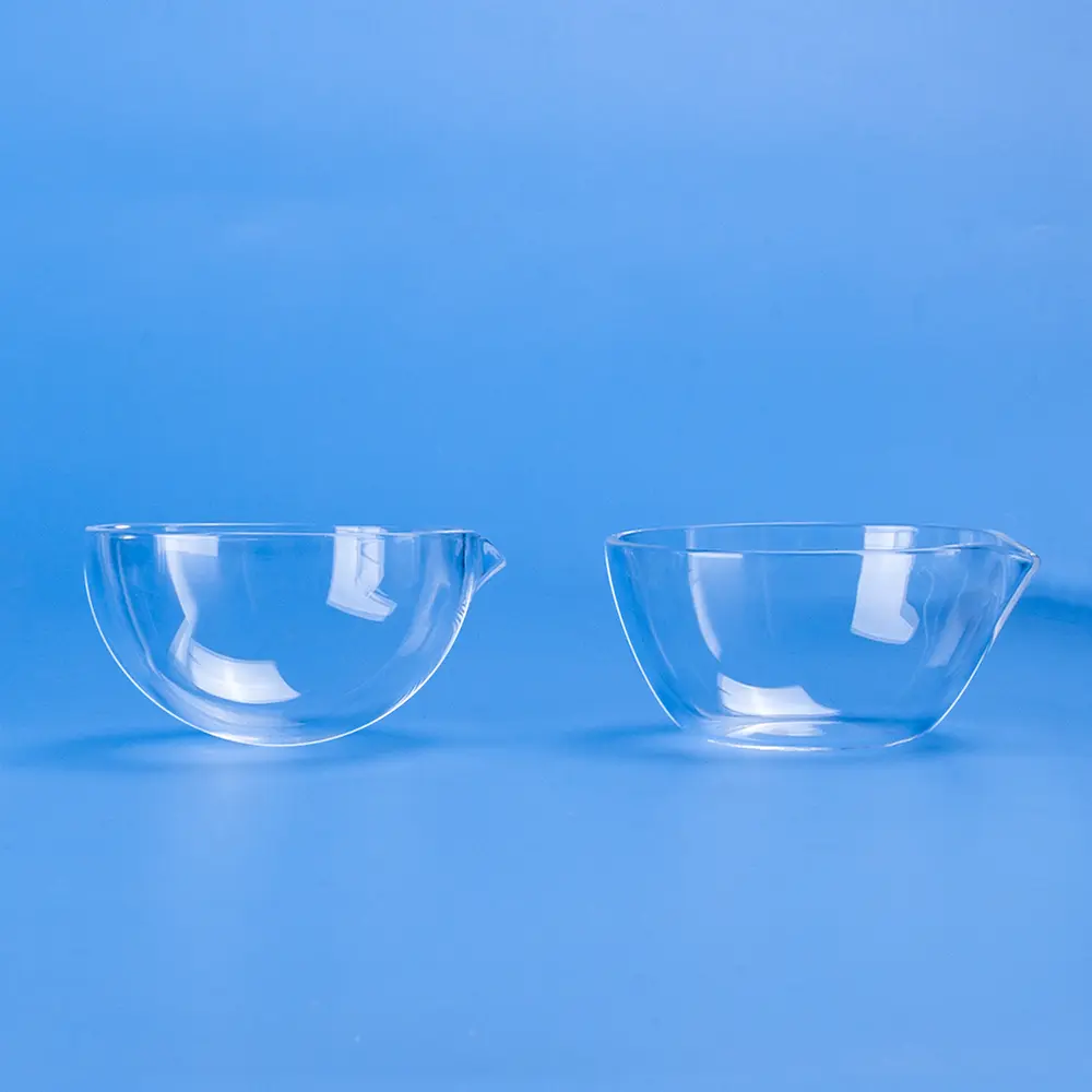 Side profile view of two clear quartz evaporating dishes with spouts.