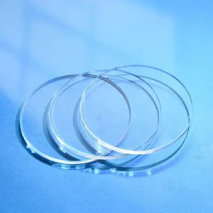Several thin clear circular quartz discs displayed overlapping against a blue background