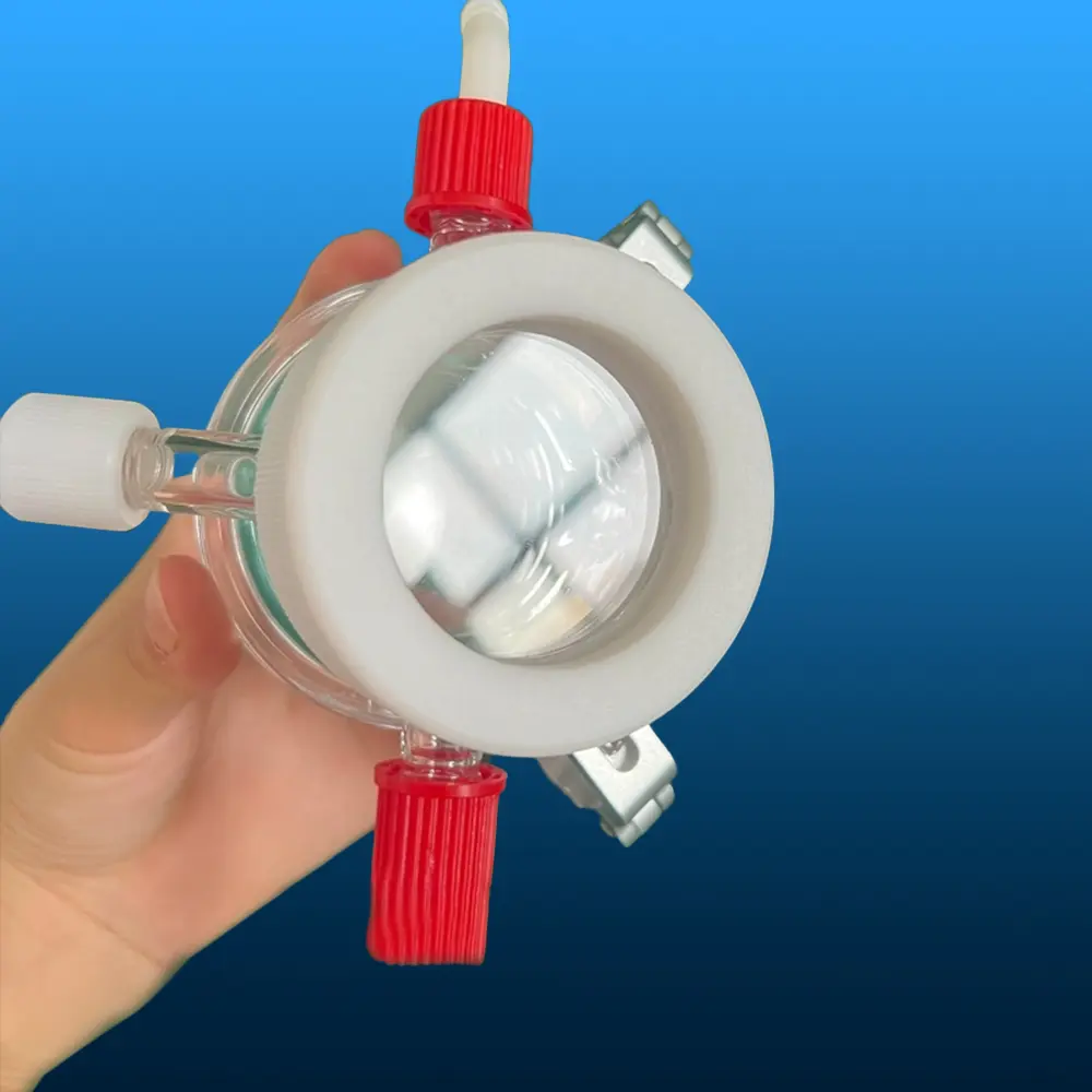 Bottom view of a quartz photocatalytic reactor held in hand, showcasing the reaction window and clamp assembly.