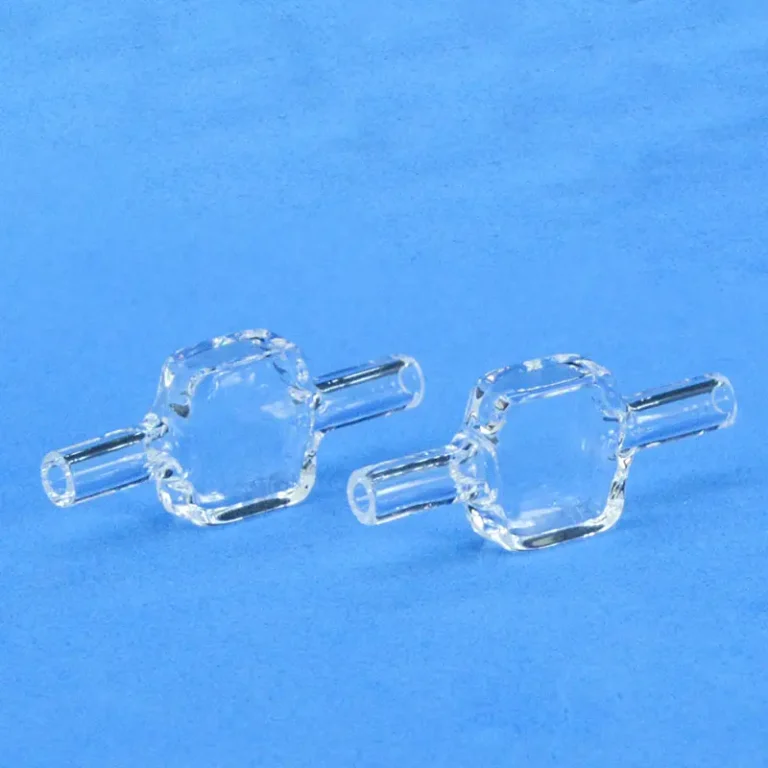 Pair of identical quartz fluorescence flow cells for spectroscopy, shown on a light blue background