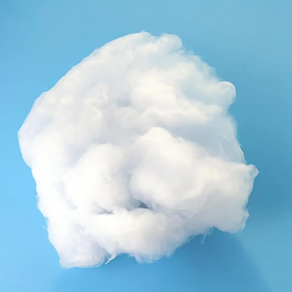 A loose, fluffy clump of white quartz wool fibers shown on a blue surface