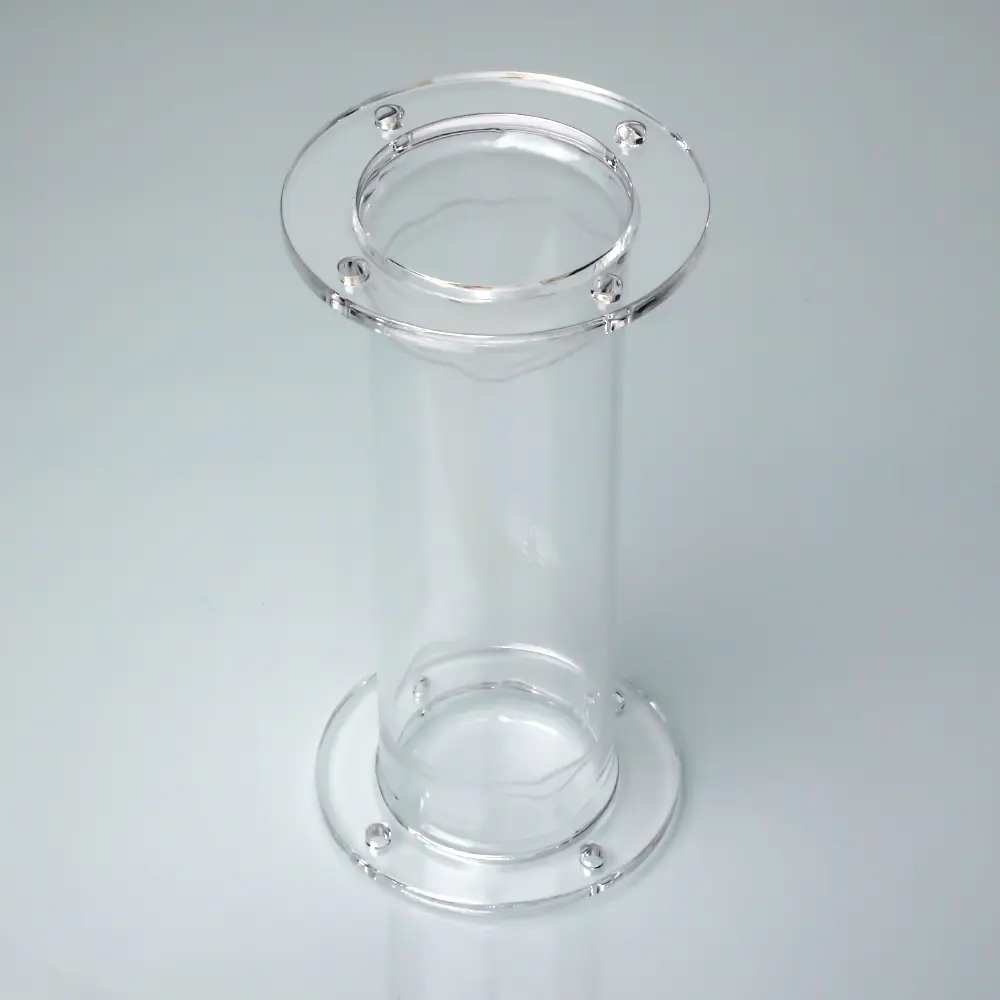 High-angle view of a clear double flanged quartz process tube standing on a light grey background