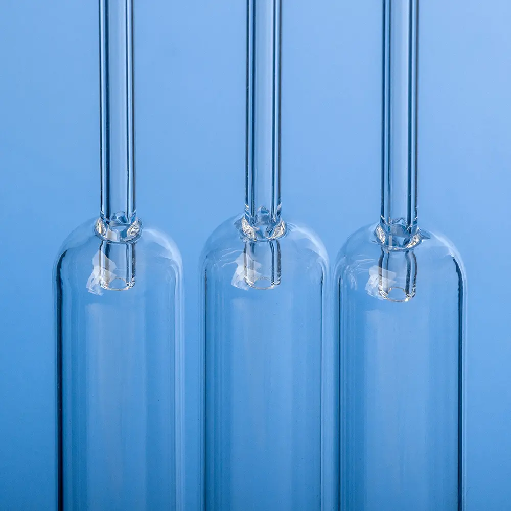 Three clear quartz tubes with specialized ends (e.g., rounded or constricted) for packed combustion reactors.