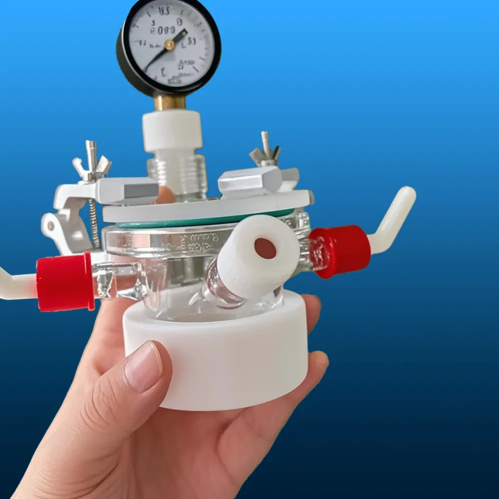 Hand holding a complete quartz photocatalytic reactor assembly showing side ports and PTFE base
