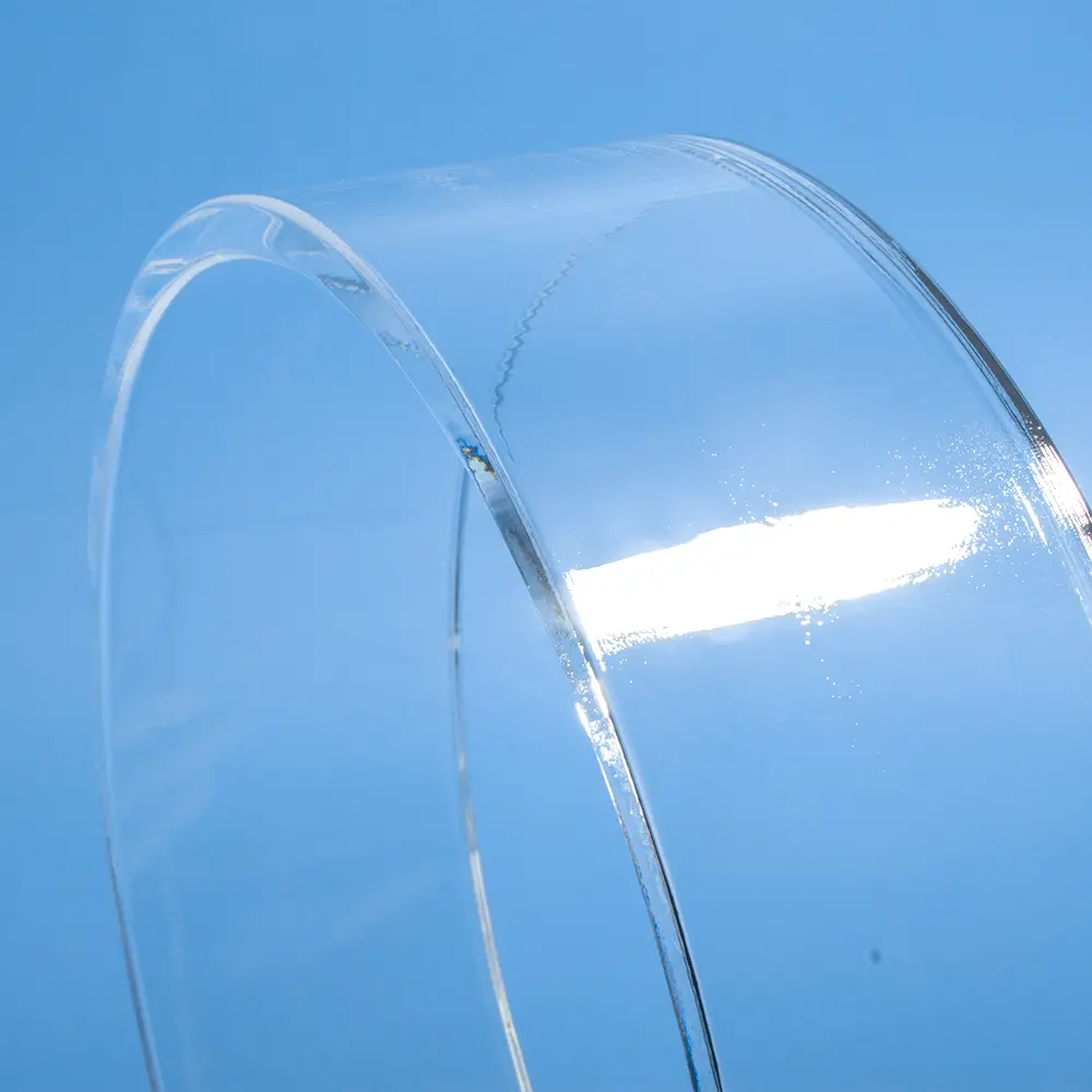 Close-up of the smooth, polished edge of a clear quartz glass ring on a blue background.