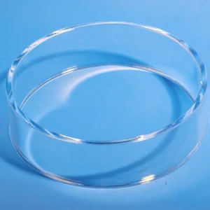 High-angle view of a clear polished quartz ring lying flat on a blue surface