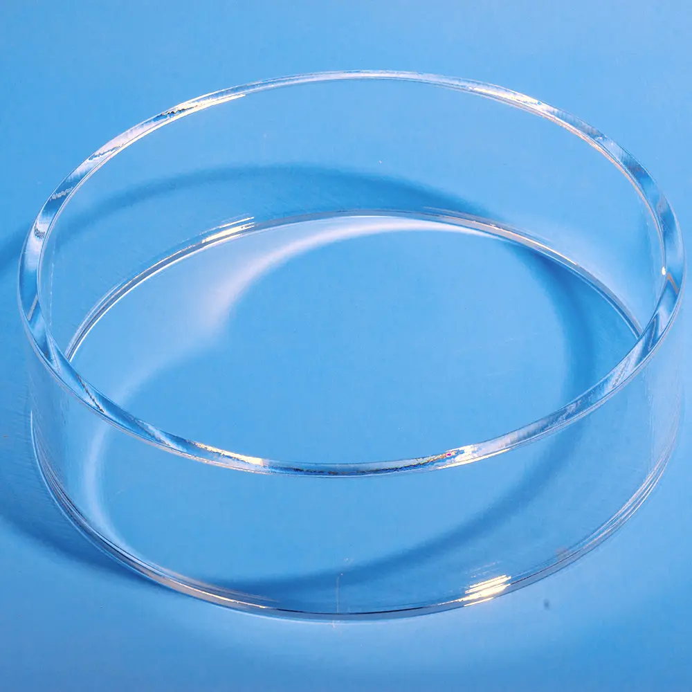 High-angle view of a clear polished quartz ring lying flat on a blue surface